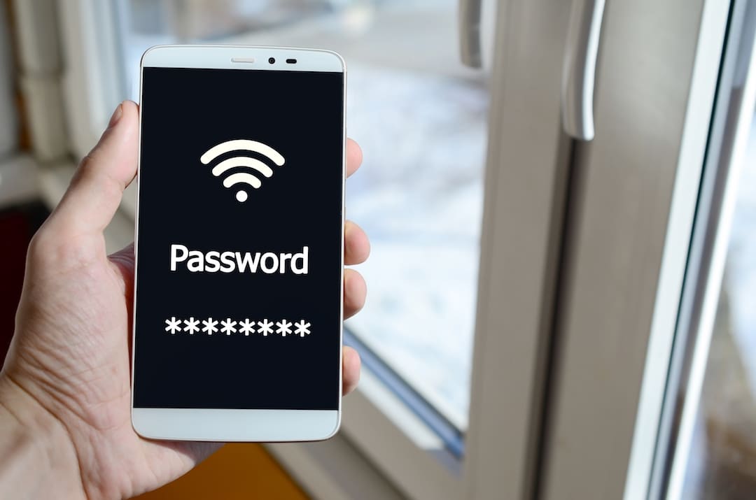 A Person Sees A White Inscription On A Black Smartphone Display That Holds In His Hand. | Featured image for are password managers safe blog.