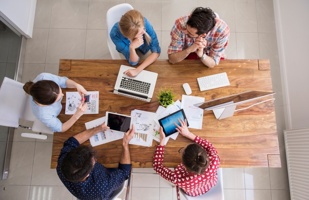 [Overhead Shot of Bespoke Office Staff Working at Desk] | Featured image for Benefits of Office 365 for Business